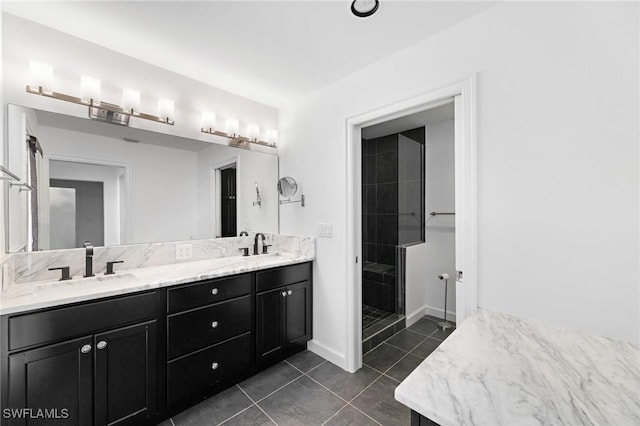 bathroom featuring tile patterned flooring, vanity, and a tile shower