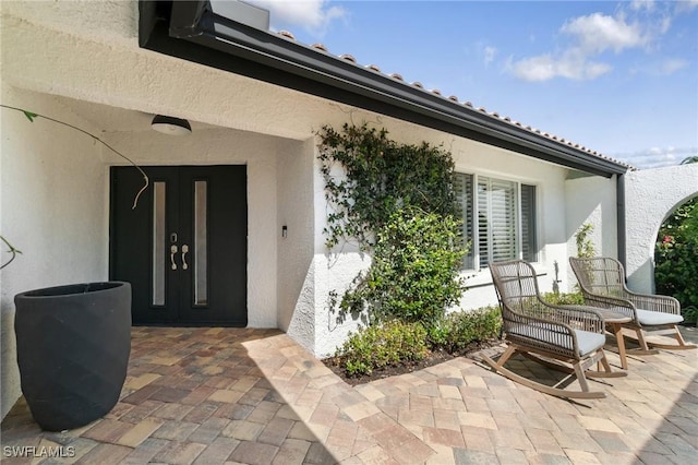 entrance to property with a patio and stucco siding