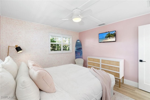 bedroom featuring baseboards, light wood-type flooring, visible vents, and a ceiling fan