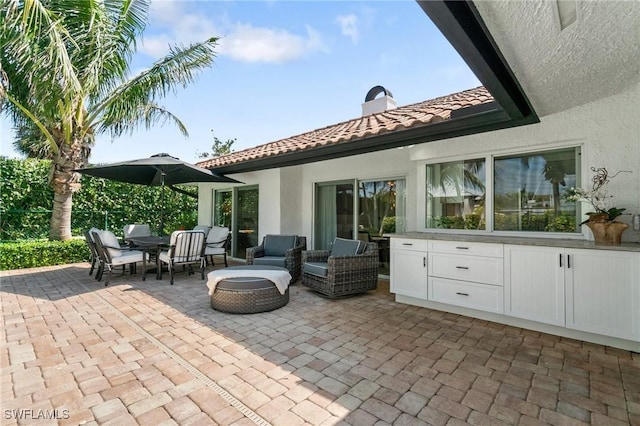 view of patio with an outdoor living space with a fire pit