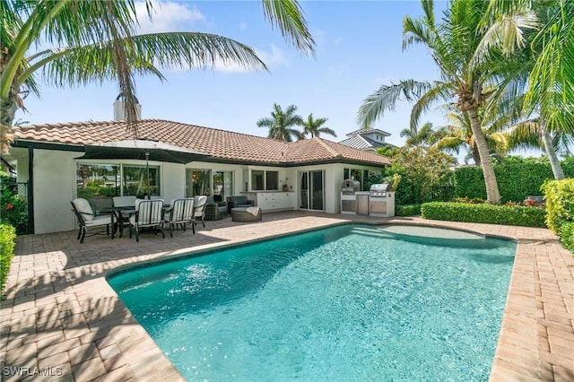 back of property with stucco siding, a tiled roof, a patio, and area for grilling