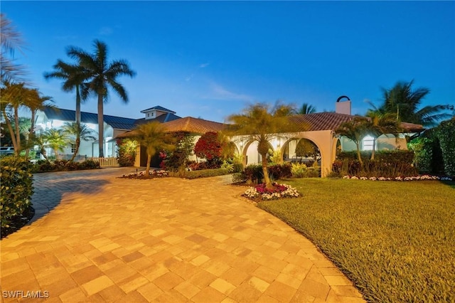 view of front of home with a front lawn and decorative driveway