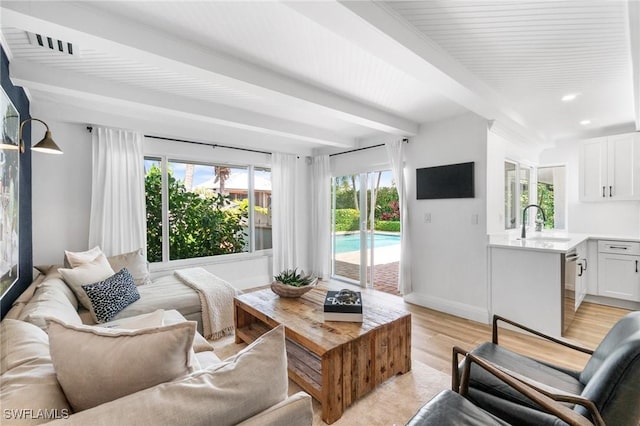 living area featuring recessed lighting, visible vents, light wood-style flooring, beamed ceiling, and baseboards