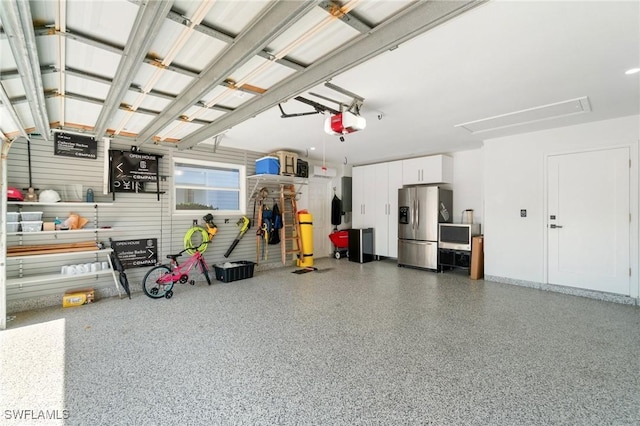 garage featuring a garage door opener and stainless steel fridge with ice dispenser