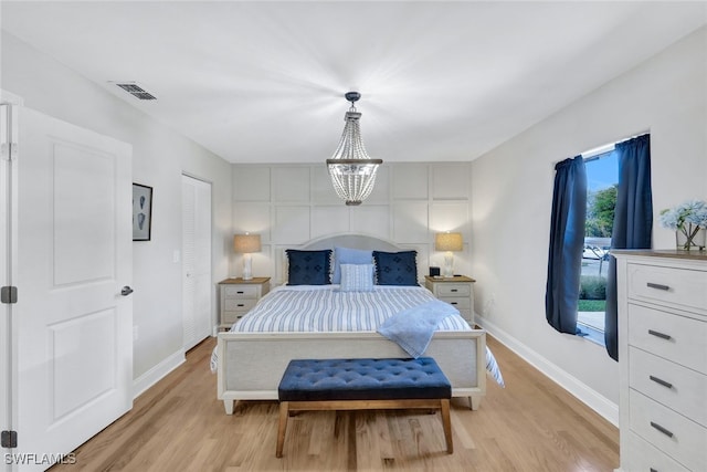 1533 San Marco Rd, Marco Island, FL 34145 - bedroom with baseboards, visible vents, a chandelier, and light wood-style floors