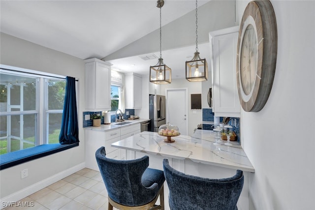 1533 San Marco Rd, Marco Island, FL 34145 - kitchen with vaulted ceiling, stainless steel appliances, a sink, white cabinets, and a peninsula