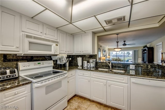 kitchen with sink, white appliances, decorative light fixtures, and white cabinets