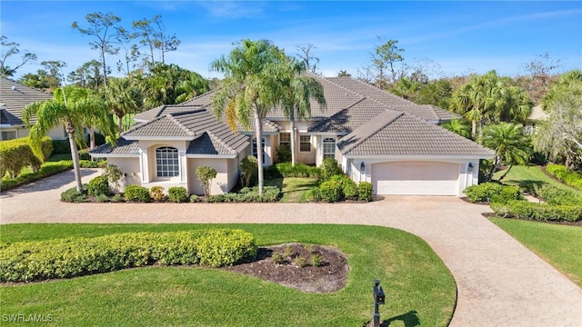 mediterranean / spanish-style home featuring a garage and a front lawn