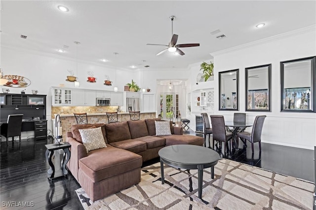 living room with hardwood / wood-style flooring, ornamental molding, and ceiling fan