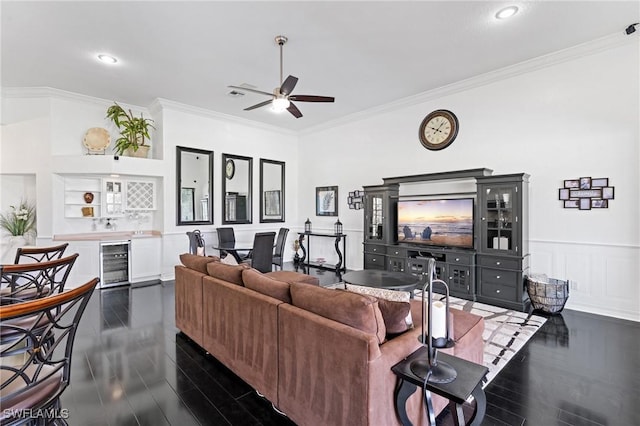 living room with bar, crown molding, dark hardwood / wood-style flooring, ceiling fan, and beverage cooler