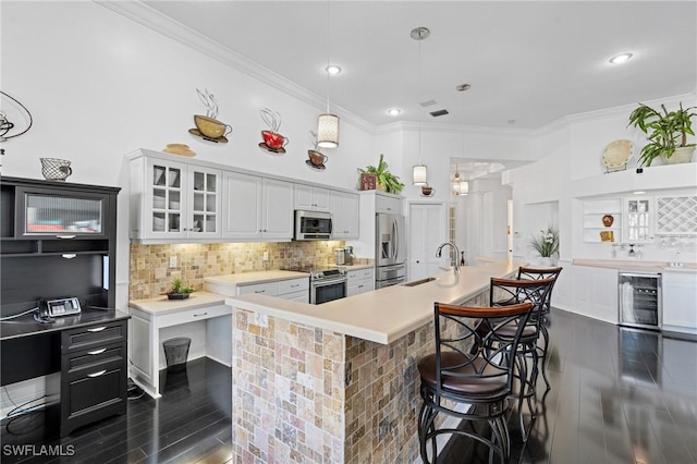 kitchen featuring sink, hanging light fixtures, an island with sink, stainless steel appliances, and beverage cooler