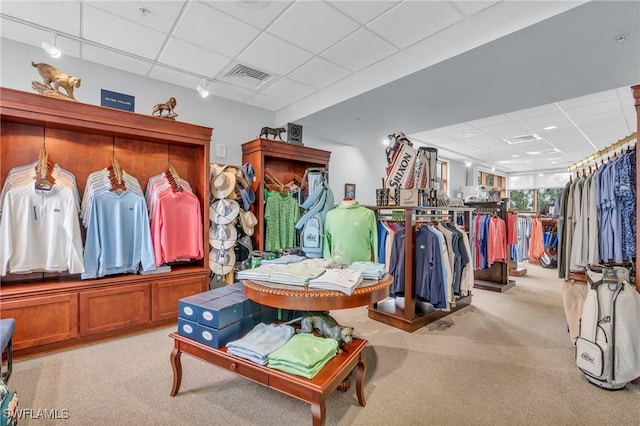 walk in closet featuring light colored carpet and a drop ceiling