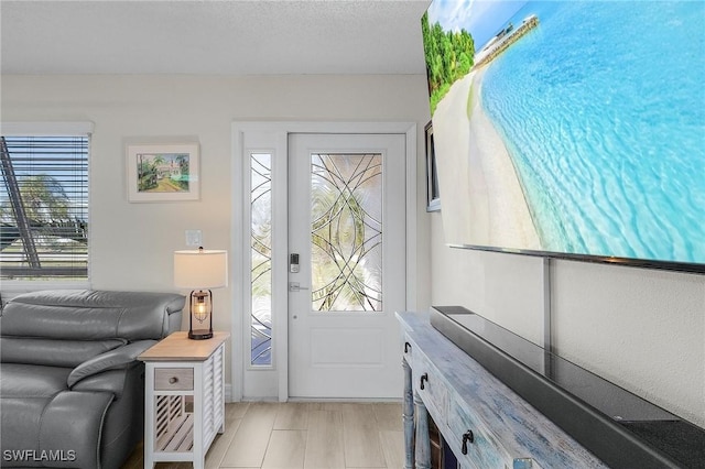 foyer entrance with a textured ceiling