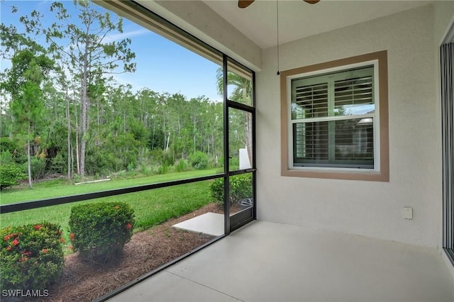 unfurnished sunroom with ceiling fan