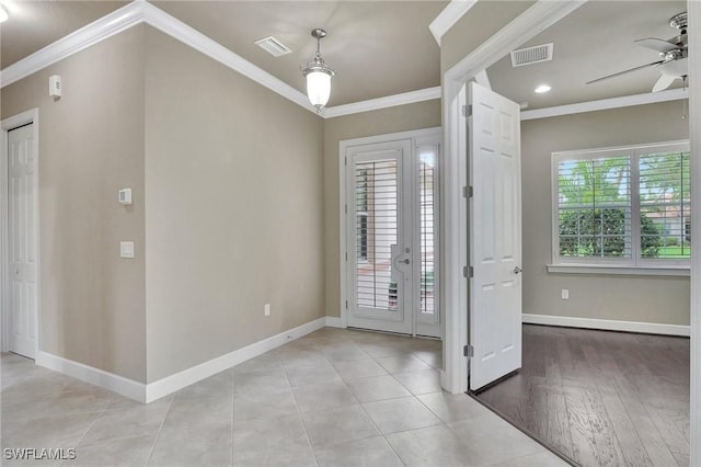 tiled foyer entrance with crown molding and ceiling fan