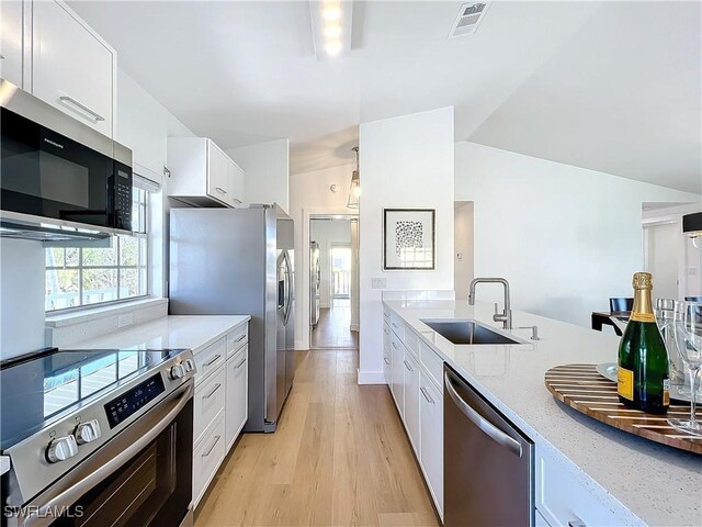 27569 Hickory View Dr, Bonita Springs, FL 34134 - kitchen featuring white cabinets, stainless steel appliances, visible vents, a sink, and light wood-style floors