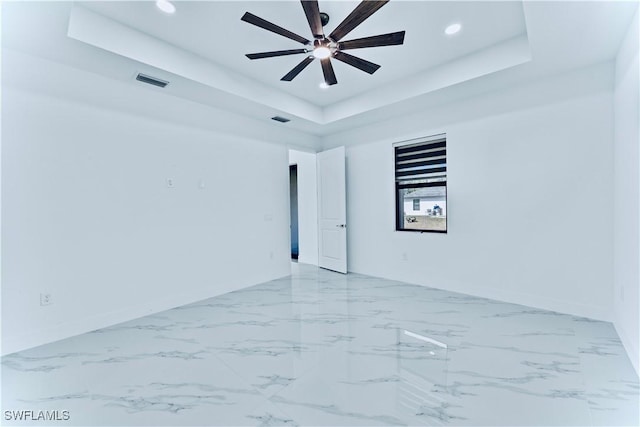 unfurnished room with a tray ceiling and ceiling fan