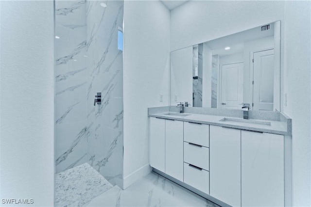 bathroom with tiled shower and vanity