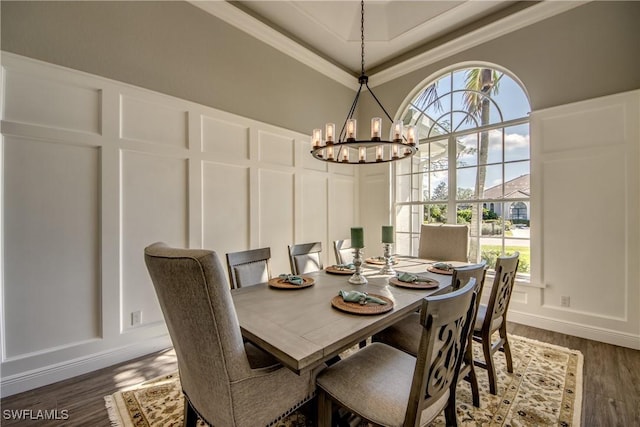 dining area with ornamental molding, a chandelier, and dark hardwood / wood-style flooring