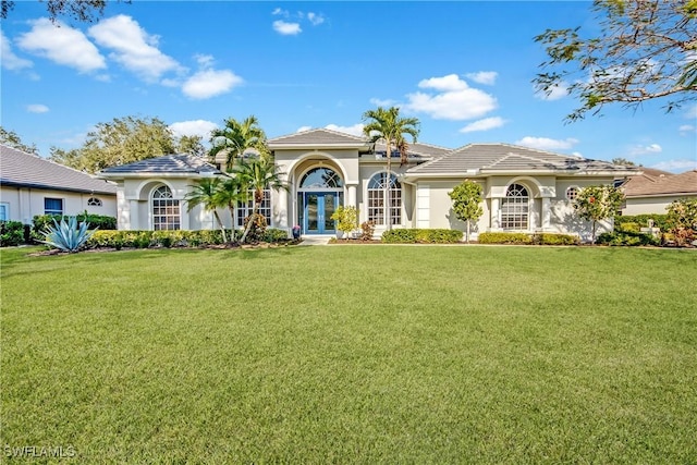 mediterranean / spanish home featuring a front yard and french doors