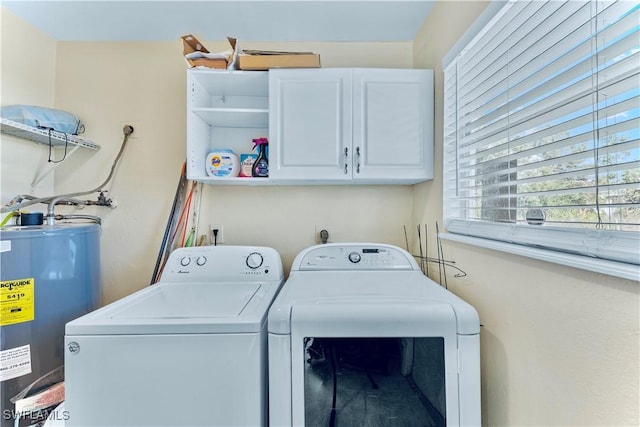 washroom featuring cabinets, washer and dryer, and water heater