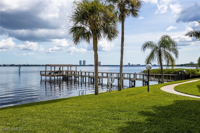 view of dock with a yard and a water view