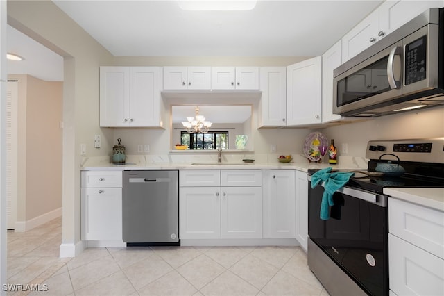 kitchen featuring stainless steel appliances, white cabinetry, sink, and light tile patterned floors