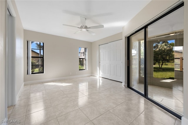 spare room with light tile patterned floors, a healthy amount of sunlight, and ceiling fan