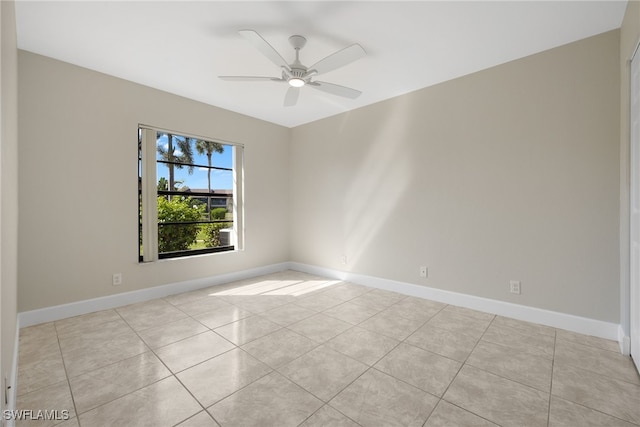 tiled spare room with ceiling fan