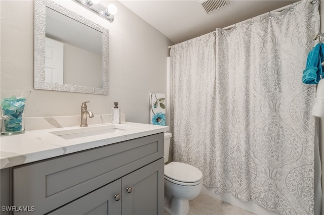 bathroom featuring vanity, tile patterned floors, and toilet