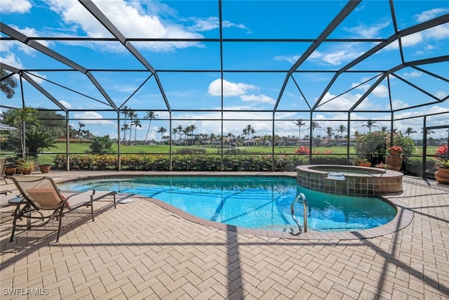 view of pool with an in ground hot tub, a patio area, and glass enclosure