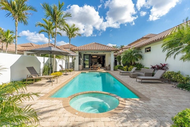 view of swimming pool featuring an in ground hot tub and a patio