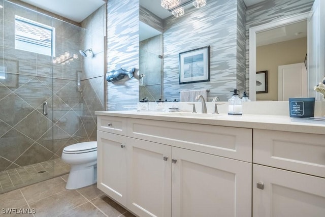 bathroom featuring vanity, toilet, tile patterned floors, and a shower with shower door