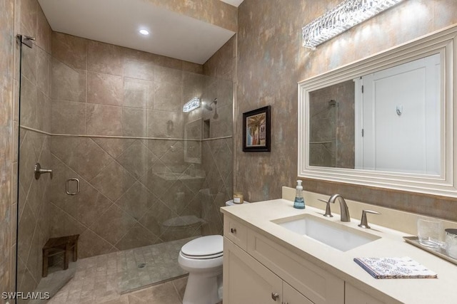 bathroom featuring tile patterned flooring, vanity, toilet, and walk in shower