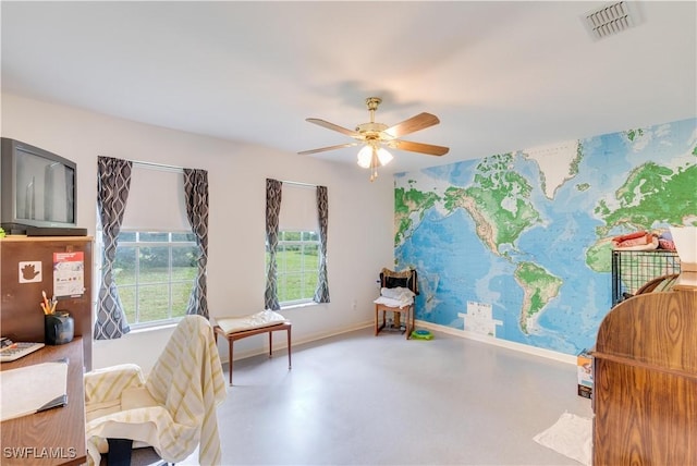 sitting room featuring concrete flooring and ceiling fan