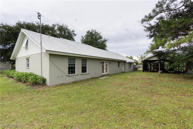 rear view of property featuring french doors and a lawn