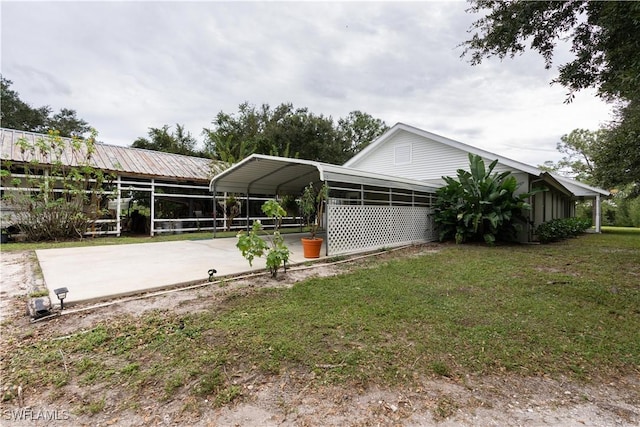 view of side of property featuring a yard and a carport