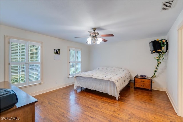 bedroom with multiple windows, ceiling fan, and light hardwood / wood-style flooring