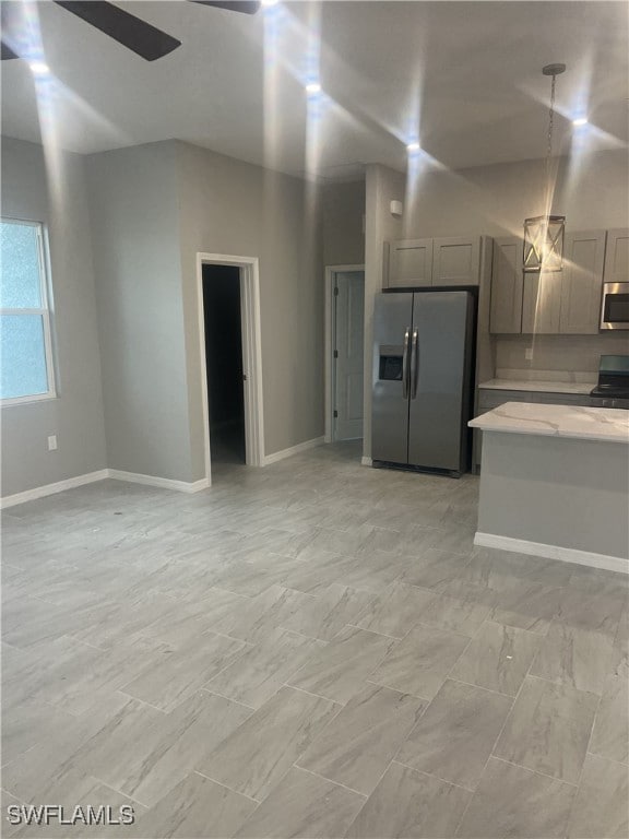 interior space with pendant lighting, ceiling fan, stainless steel appliances, and gray cabinets