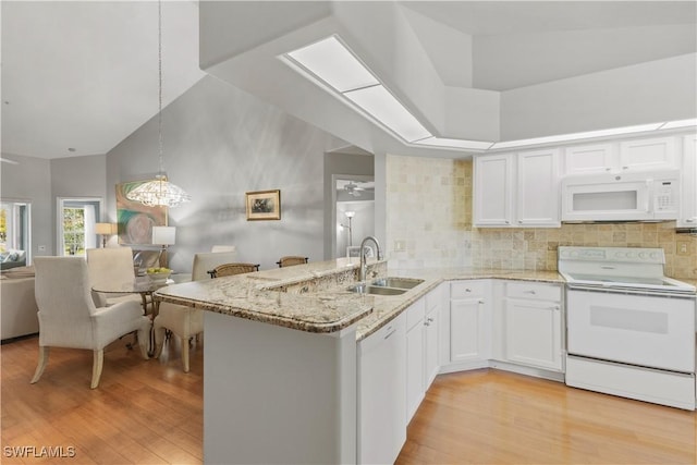 kitchen featuring sink, white appliances, white cabinetry, decorative light fixtures, and kitchen peninsula