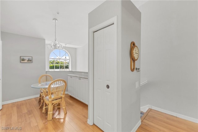 dining space with a notable chandelier and light hardwood / wood-style flooring