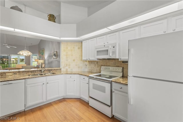 kitchen with white cabinetry, white appliances, and sink