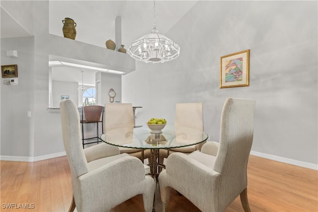 dining space featuring an inviting chandelier, vaulted ceiling, and hardwood / wood-style floors