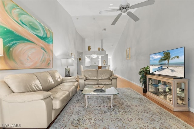 living room with high vaulted ceiling, light hardwood / wood-style floors, and ceiling fan