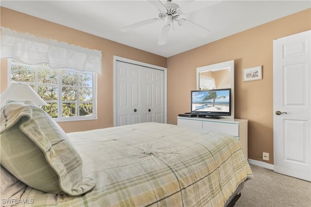 carpeted bedroom featuring ceiling fan and a closet