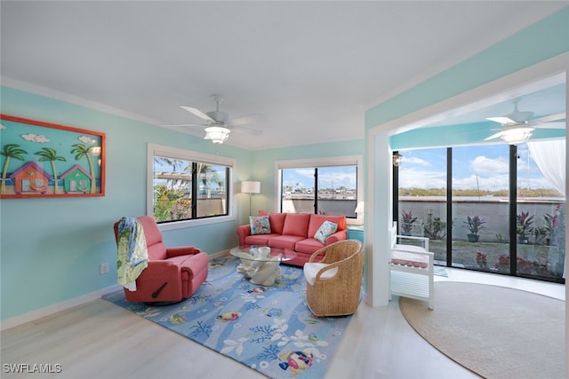 living room with crown molding, wood-type flooring, and ceiling fan