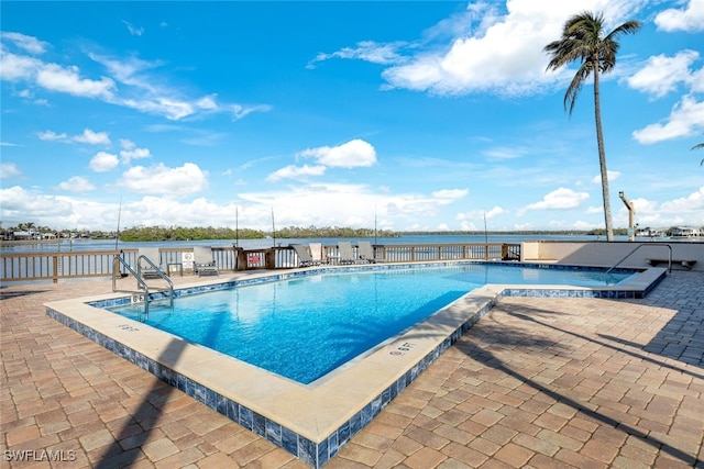 view of swimming pool featuring a patio and a water view