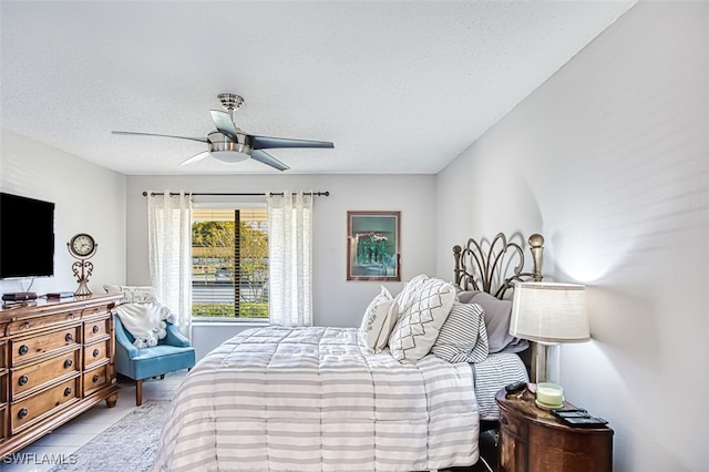 bedroom with light tile patterned flooring, ceiling fan, and a textured ceiling