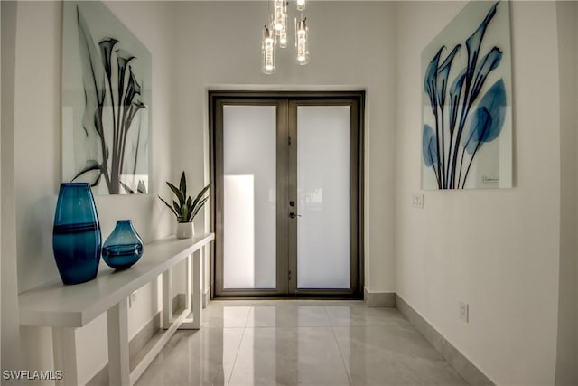 doorway featuring light tile patterned flooring, a notable chandelier, and french doors