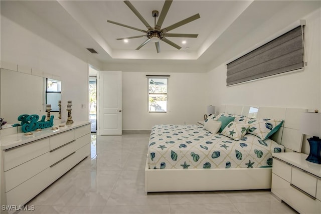 bedroom with a tray ceiling and ceiling fan